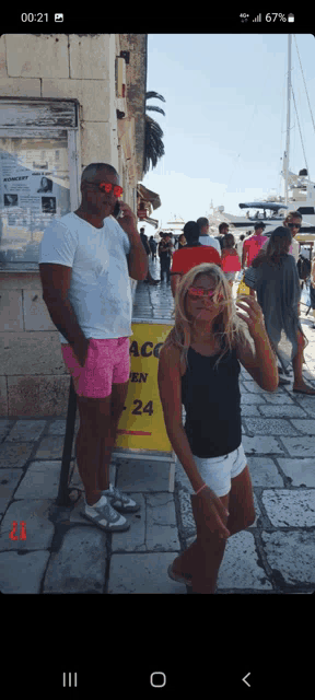 a man and a girl are standing in front of a yellow sign that says acc 24