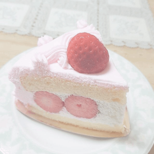 a slice of cake with strawberries on top on a plate