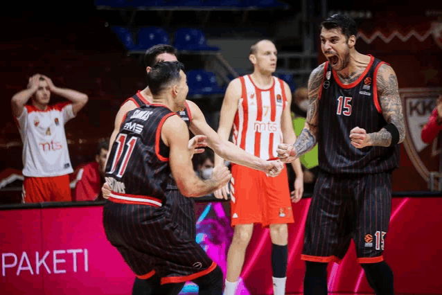 a basketball player with the number 15 on his jersey celebrates with his teammate