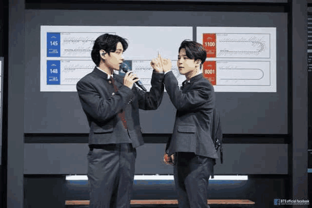 two men in suits are giving each other a high five while standing next to each other .