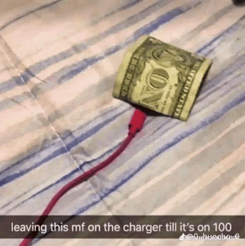 a dollar bill is plugged into a charger on a bed