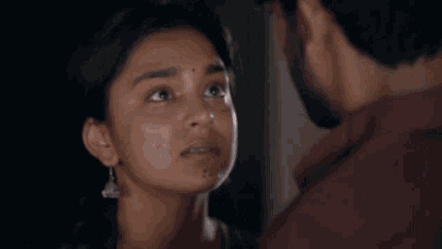 a man with a beard and a woman are looking at each other in a room .