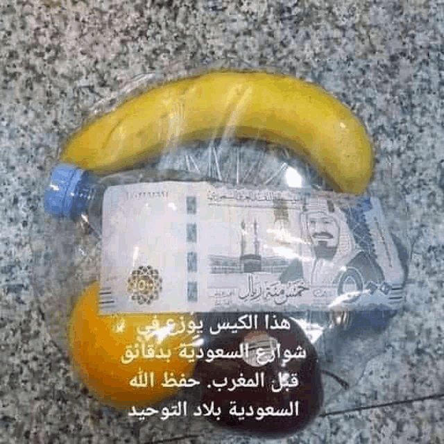 a banana is wrapped in plastic next to a bottle of water and an orange