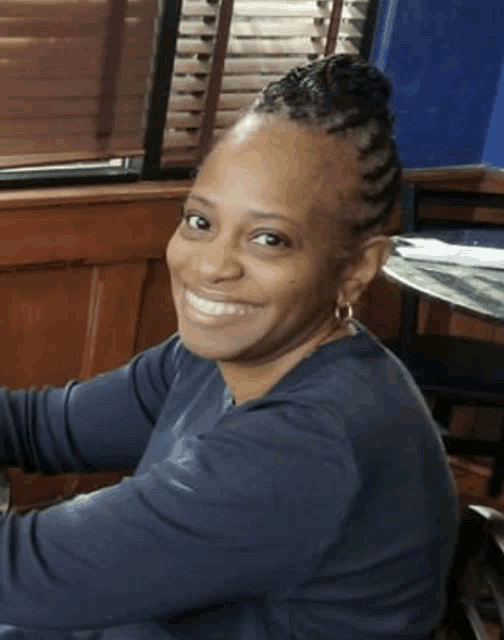 a woman with braids in her hair is smiling for the camera