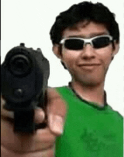 a man wearing sunglasses and a green shirt is pointing a gun .