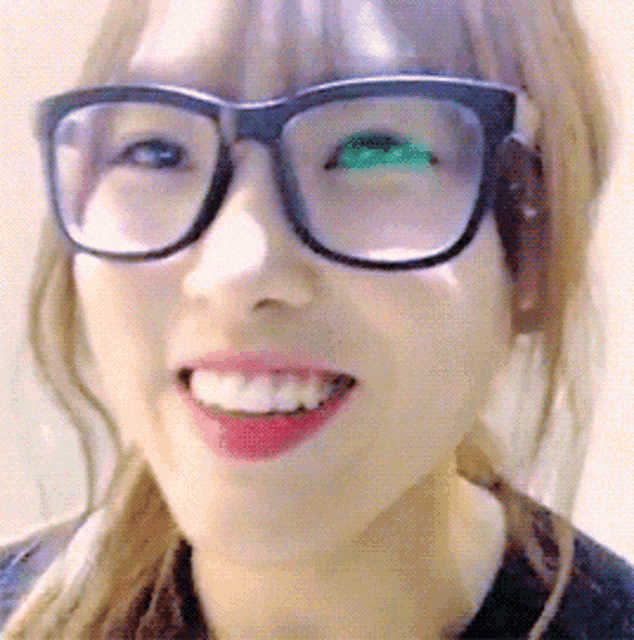 a woman wearing glasses with green lenses is smiling