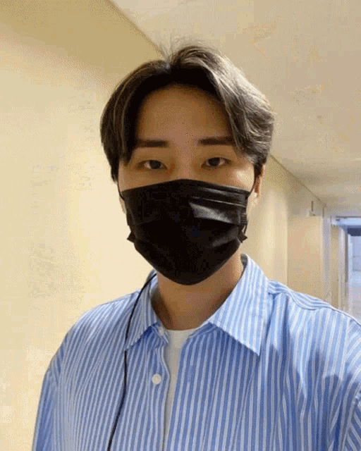 a man wearing a black mask and a blue striped shirt