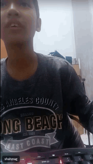 a boy wearing a long beach east coast shirt