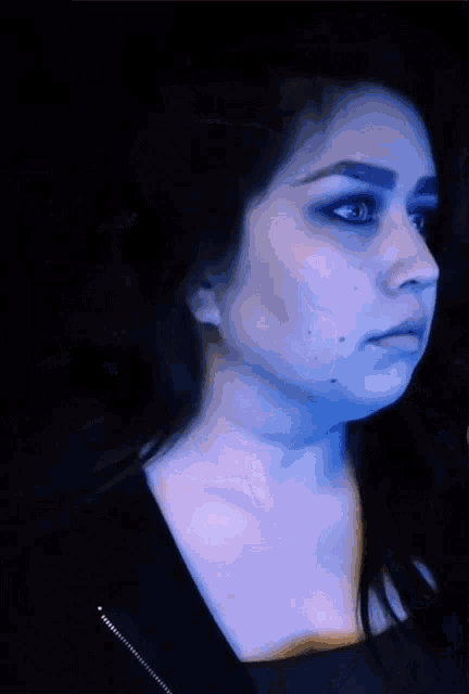 a woman with a surprised look on her face has blue eyes