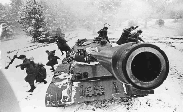 a black and white photo of soldiers fighting a tank in the snow with a large cannon in the foreground