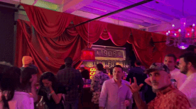 a group of people in a club with a sign that says 1906