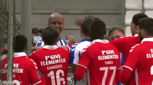 a group of soccer players wearing red and white jerseys that say give elementar