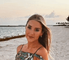 a woman is standing on a beach next to the ocean .