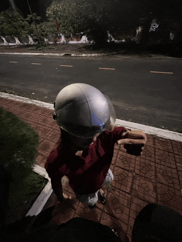 a person wearing a helmet and a red shirt is pointing