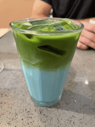 a blue and green drink in a glass