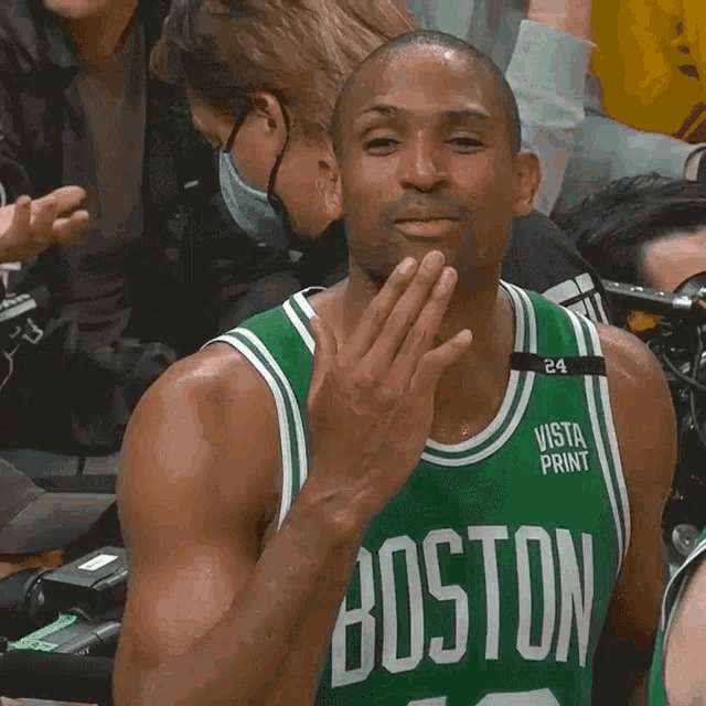 a man wearing a boston jersey with vista print on the front