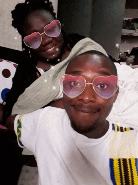 a man wearing heart shaped sunglasses is smiling next to a woman