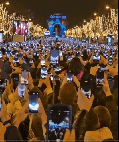 a crowd of people holding up their cell phones in front of a sign that says 00:00:00