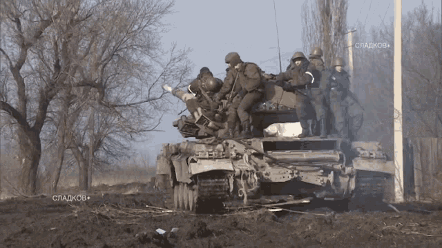 a group of soldiers are riding on top of a tank with the words " сладков " on the bottom