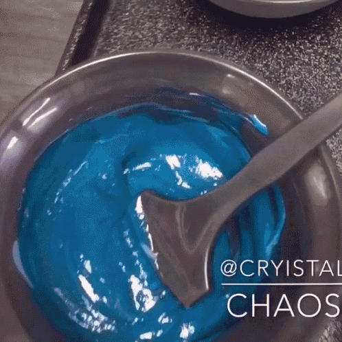 a close up of a bowl of blue and purple liquid with the words @cryista chaos below it