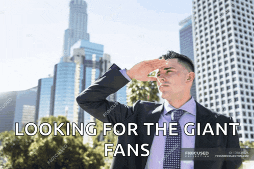 a man in a suit and tie is looking for giant fans