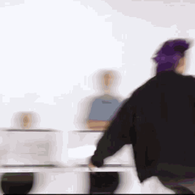 a blurry picture of a person with purple hair walking .