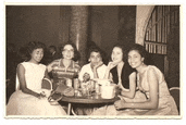 a group of women are sitting around a table in a restaurant .