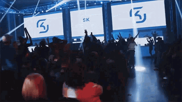 a crowd of people in front of a screen that says sk on it