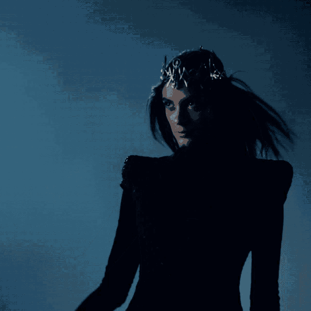 a woman wearing a black dress and a silver crown