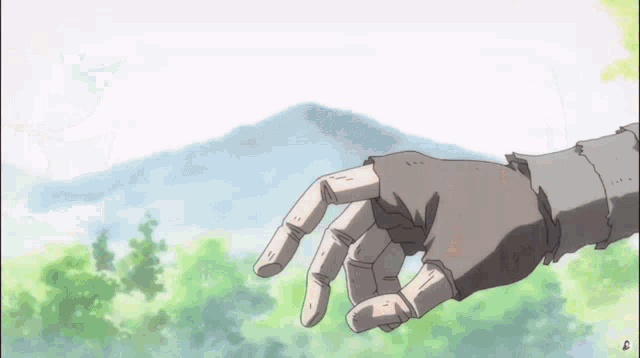a hand is reaching out towards a mountain