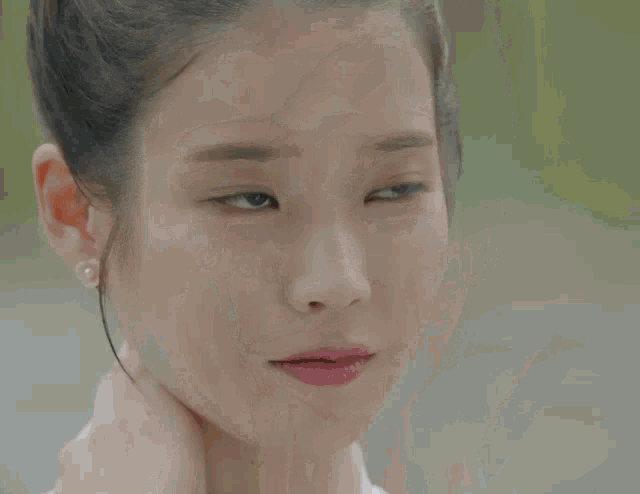 a close up of a woman 's face with pearl earrings