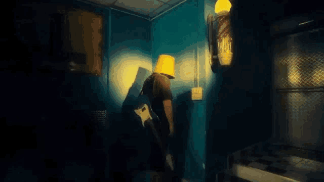 a man is standing in a dark room with a bucket on his head .