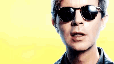 a man wearing sunglasses is making a funny face .