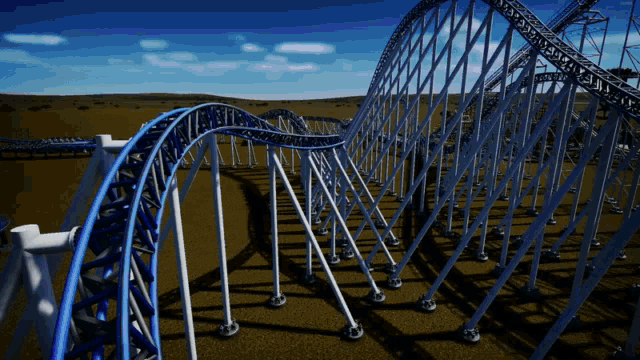 a roller coaster going through a field with a blue sky behind it