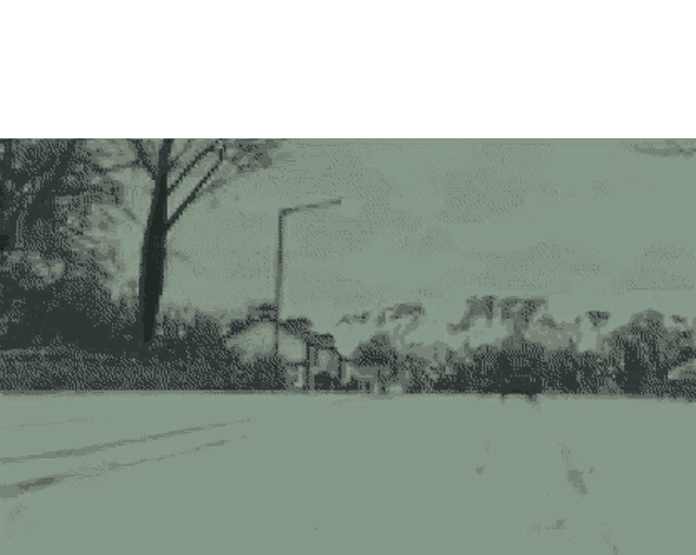 a pixelated image of a truck driving down a street with trees in the background