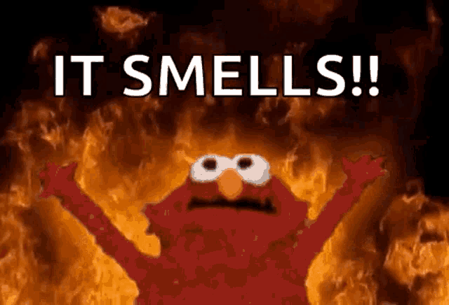 elmo from sesame street is standing in front of a fire with the words `` it smells '' .