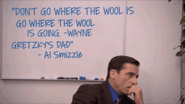 a man sits in front of a white board with a quote from ai smizzle