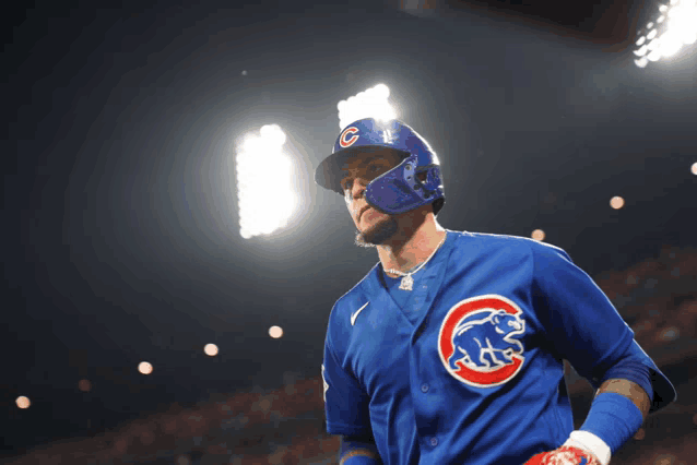 a baseball player wearing a blue jersey with a cubs logo