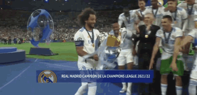 a soccer player is holding a trophy in front of a sign that says real madrid campeon de la champions league