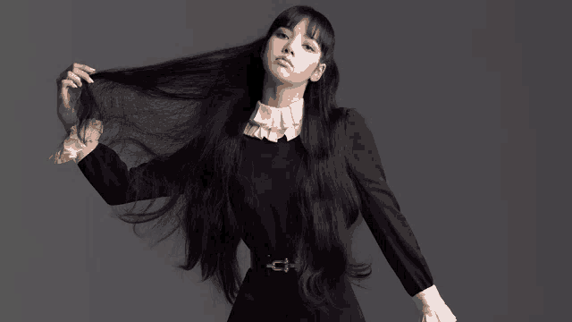 a woman with very long black hair wearing a black dress