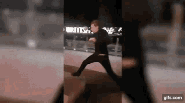 a man is jumping in the air in front of a sign that says ' british ' on it