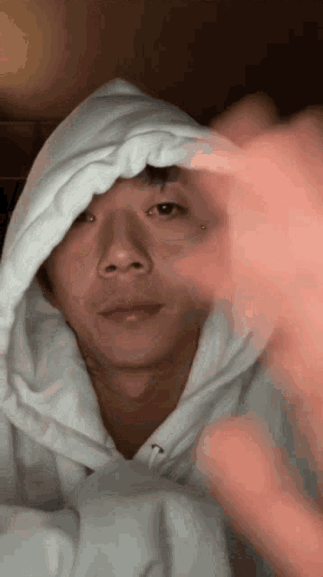 a man wearing a white hoodie with the letter n on the front