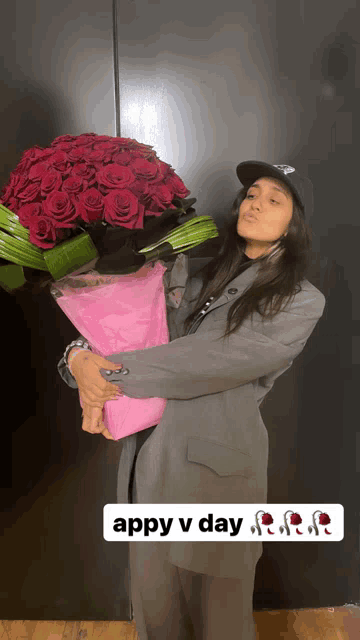 a woman holding a large bouquet of red roses with appy v day written on the bottom