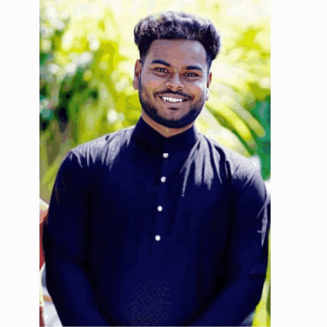 a man with a beard is wearing a black shirt and smiling for the camera