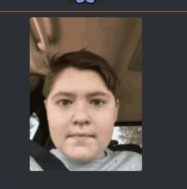 a boy is sitting in the back seat of a car and taking a selfie