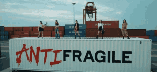 a group of women standing on top of a container that says anti fragile