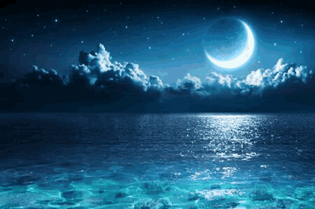 a crescent moon shines over the ocean at night