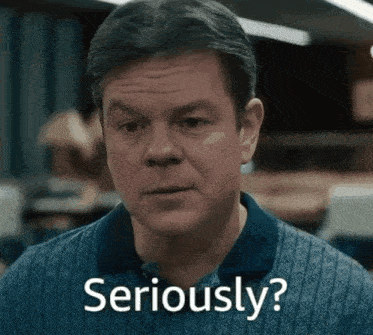 a man in a blue shirt says seriously in front of his face