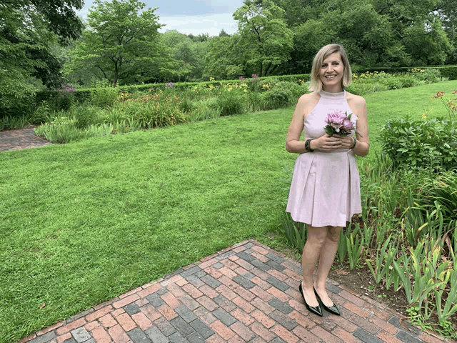 a woman in a pink dress holding a bouquet of flowers
