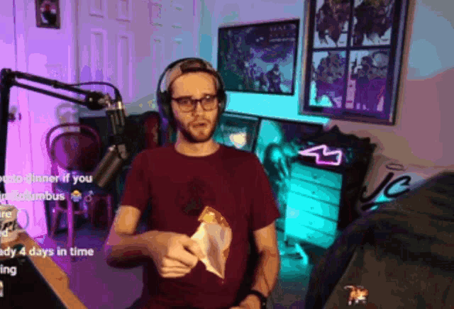 a man wearing headphones holds a bag of food in front of a microphone